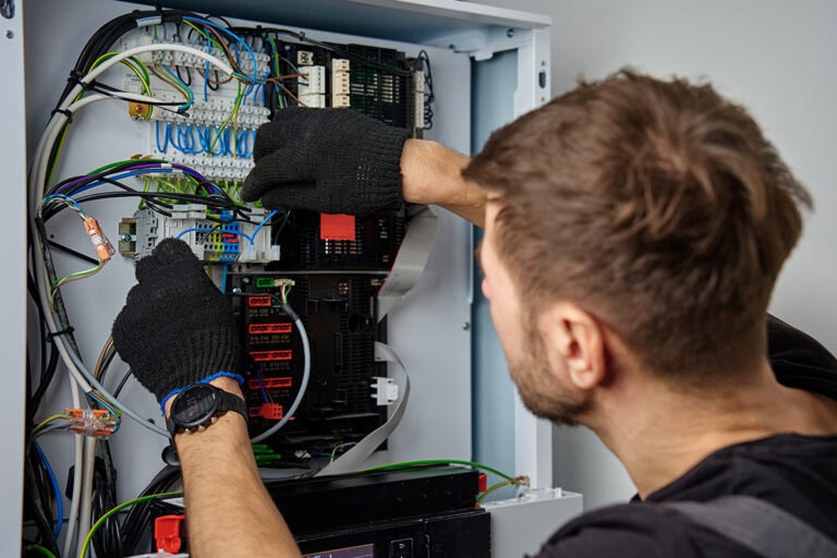 An electrician working on a electrical panel
